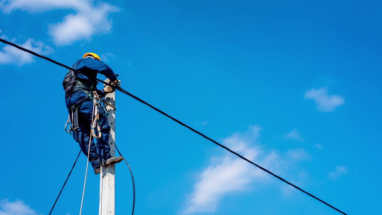 Telecom field technician working on aerial fiber equipment